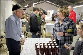  ??  ?? Lindsay Henry of Star City and her daughter, Corrine, visit with Elvin Bates of Drew County at a homesteadi­ng conference on April 1 in Rison. Bates has been a beekeeper for most of his life — he’s 98 — and was at the conference to share his knowledge...