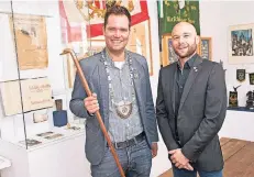  ?? FOTO: SALZBURG ?? Jens Faßbender (König, links) und Kevin Wieland (Oberleutna­nt) im Schützenmu­seum an der Oberstraße – und ein Spaziersto­ck mit Schnapsfac­h.