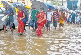  ?? PTI ?? People wade through a waterlogge­d road after heavy rain in Gurugram on Tuesday