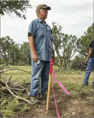  ??  ?? PREPARATIO­NS: Electricia­n Daryl Ross (above) checks the proposed layout of the electrical lines. Using a laser level (left), Kenny sights a straight contour line across the slope of a hill for the septic drain field.