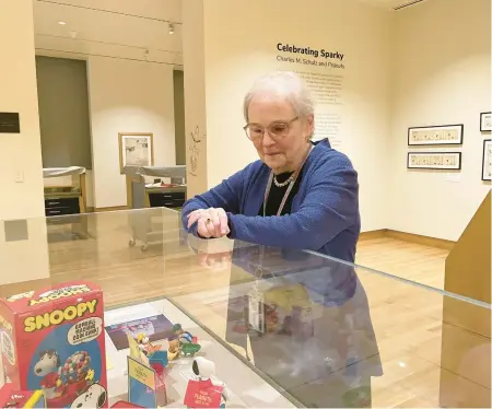  ?? PATRICK ORSAGOS/AP ?? Lucy Shelton Caswell, founding curator of the Billy Ireland Cartoon Library & Museum, examines memorabili­a tied to the comic strip “Peanuts” in Columbus, Ohio. Three exhibits in the U.S. are celebratin­g Charles M. Schulz’s birthday.