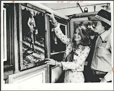  ?? [THE OKLAHOMAN ARCHIVES] ?? Gretchen Jackson adjusts one of paintings she and husband Bill showed at the Festival of the Arts in 1975.