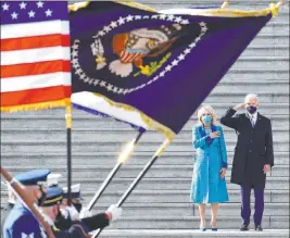  ?? David Tulis The Associated Press ?? President Joe Biden salutes as his wife, Jill, puts her hand over her heart as they review the troops from the steps of the U.S. Capitol during Wednesday’s inaugurati­on.