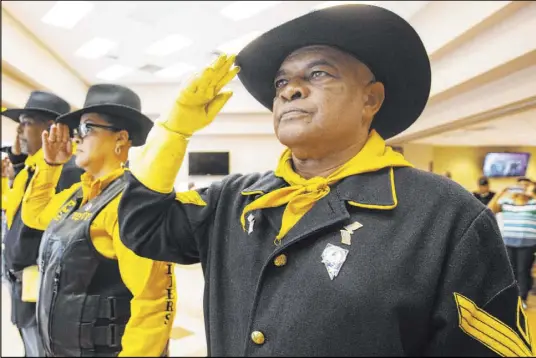  ?? Michael Blackshire Las Vegas Review-Journal ?? Mitchell Sayles, right, Tiffany Barnett and Kelly Hawthorne salute Saturday during Buffalo Soldiers Day at the Doolittle Senior Center.