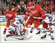  ?? Paul Sancya / Associated Press ?? New York Rangers goaltender Alexandar Georgiev (40) stops a shot as Detroit Red Wings center Dylan Larkin (71) jumps to clear space for the shot in the second period on Wednesday in Detroit.