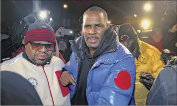  ?? Chris Sweda / Chicago Tribune via AP ?? R&amp;B star R. Kelly turns himself in at 1st District police headquarte­rs in Chicago on Friday night, hours after authoritie­s announced multiple charges against him of aggravated sexual abuse involving four victims, including at least three between the ages of 13 and 17.