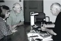  ??  ?? Walter evaluating coins with customers at a recent event.