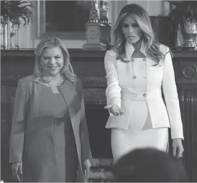  ?? ALEX WONG / GETTY IMAGES ?? Sara Netanyahu, left, wife of Israeli Prime Minister Benjamin Netanyahu, and Melania Trump, wife of U.S. President Donald Trump, arrive at the East Room of the White House before a joint news conference on Wednesday in Washington, D.C. The president...