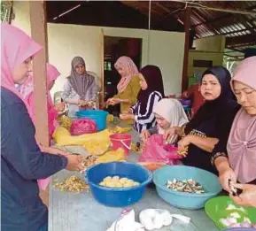  ?? [FOTO SAFURI KAMARUDDIN /BH] ?? Petugas membantu memasak untuk mangsa banjir di PPS Kompleks Rakan Muda, Baling.