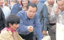  ??  ?? Prime Minister Hun Sen talks with a garment worker during a visit to the Phnom Penh Special Economic Zone. He approved an 11% rise this year in the minimum wage, even higher than what employers and workers had already agreed on.