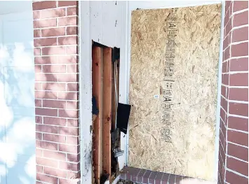  ?? — Reuters photo ?? The doorway of a home that was hit with a fatal parcel bomb is seen boarded-up in Austin.