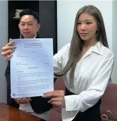  ?? ?? Siew Pui Yi holding the civil suit documents.