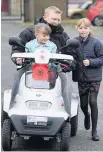  ??  ?? Andy on his scooter trek of Britain in 2015 and taking a ride with daughters Chloe, six, and Hannah, 10