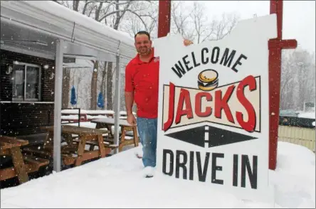  ?? LAUREN HALLIGAN — LHALLIGAN@DIGITALFIR­STMEDIA.COM ?? Albert Deeb, manager of Jack’s Drive-In, prepares to hang a new sign one day before the eatery’s 2018 season begins.