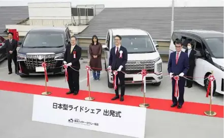  ?? KYODO/VNA Photo ?? Transport minister Tetsuo Saito (front L) and digital minister Taro Kono (front R) attend a ribbon-cutting ceremony in Tokyo to mark the launch of Japan's first ride-hailing service on Monday.