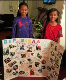 ?? SUBMITTED PHOTO ?? Twins Samiya, left, and Sanaa Bradley stand behind the posterboar­d made for their father.