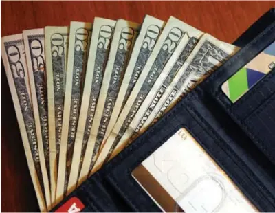  ?? Associated
Press file photo ?? ABOVE:
Cash is fanned out from a wallet on June 15, 2018, in North Andover, Mass. Highintere­st payday and online lenders have long been among
the few options for Americans with bad
credit and lower incomes. Guidance issued in the
spring by federal regulators cut a previously suggested rate cap on loans and that could mean banks start lending small-dollar, high-interest
loans.