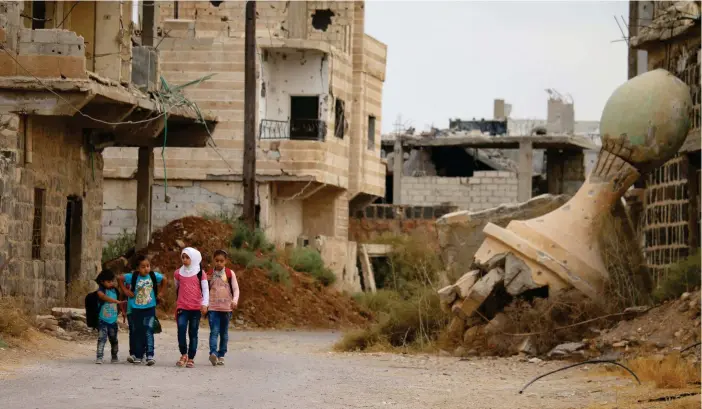  ?? FOTO: LEHTIKUVA/AFP/MOHAMAD ABAZEED ?? BEHöVER HJäLP. Skolbarn i staden Daraa vandrar bland ruinerna. Daraa är beläget i södra Syrien nära gränsen till Jordanien. Stora delar av staden är förstörd.