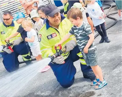  ?? Photos / Kathy Mitchell ?? Foxton volunteer firefighte­rs pose with preschoole­rs from Ohau’s ¯ Playcentre in front of their truck.