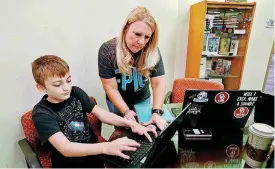  ?? [OKLAHOMAN ARCHIVES PHOTO] ?? Epic virtual charter school teacher Regina Bell helps student Eli Real, 11, of Norman, as Bell meets with students in September at Norman Central Library.