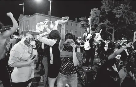  ?? EVAN VUCCI/AP ?? People protesting police brutality and the death of George Floyd shield their faces as a helicopter circles low overhead on June 1, 2020, near the White House. A Baltimore woman who was among the demonstrat­ors says she suffered lasting injuries from the incident.