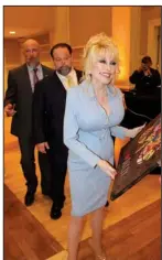  ?? ?? Dolly Parton accepts a gift.