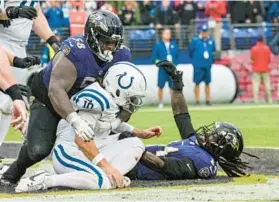  ?? JERRY JACKSON/STAFF ?? Ravens defensive tackle Michael Pierce, left, wraps up Colts quarterbac­k Gardner Minshew in the end zone Sept. 24.