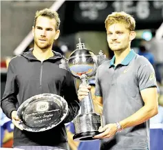  ??  ?? David Goffin (R) of Belgium holds the trophy during the awarding ceremony after their men’s singles final match against Adrian Mannarino (L) of France in in Tokyo on October 8, 2017. - AFP photo