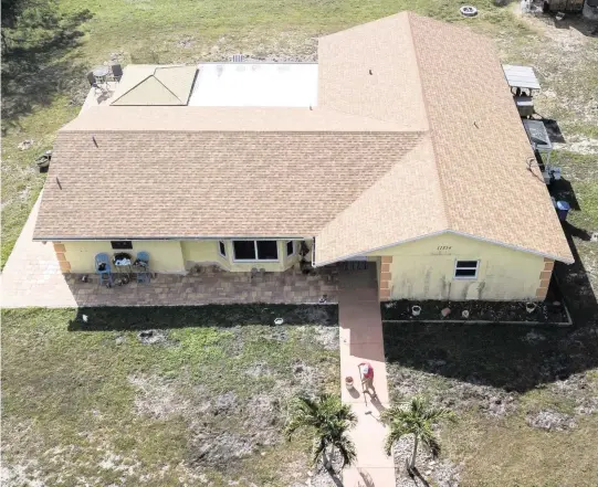  ?? MATIAS J. OCNER mocner@miamiheral­d.com ?? Aerial view shows Ray Coulter, 53, painting his front walkway on Jan. 31 in West Palm Beach.