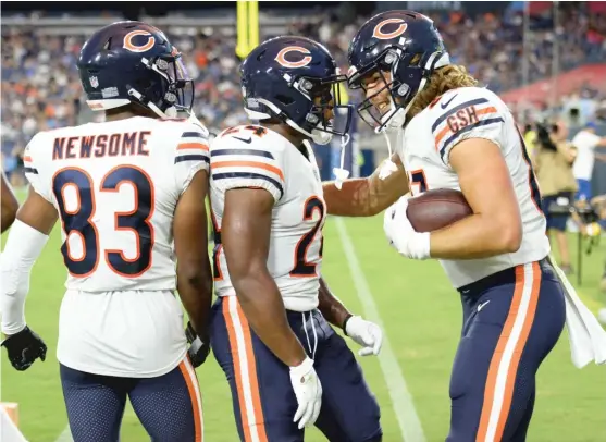  ?? AP ?? Bears tight end Jesper Horsted (right) is congratula­ted by Dazz Newsome and Khalil Herbert after his touchdown catch in the second quarter Saturday against the Titans.