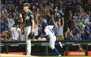  ?? DAVID BANKS — GETTY IMAGES ?? The Cubs’ Javier Baez runs the bases after hitting a home run as A’s pitcher Chris Bassitt looks on during the sixth inning Monday night in Chicago.