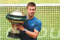  ?? AFP ?? Borna Coric poses with his trophy after defeating Roger Federer in the final of the Halle Open yesterday. The Croatian won 7-6(6) 3-6 6-2.