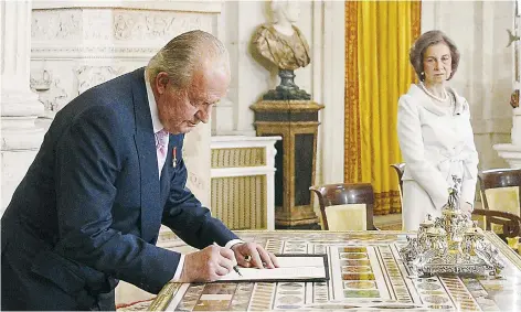  ??  ?? Imagen del 18 de junio de 2014 cuando el entonces rey Juan Carlos firma la ley orgánica sobre su abdicación en el Palacio Real de Madrid.