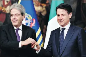  ?? ANDREAS SOLARO / AFP / GETTY IMAGES ?? Italy’s newly appointed Prime Minister Giuseppe Conte, right, receives a silver bell from former prime minister Paolo Gentiloni during the bell ceremony, signifying the start of the first cabinet meeting, at Chigi palace in Rome on Friday.