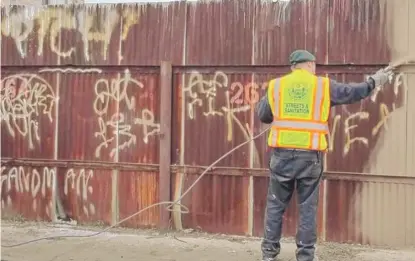  ?? PROVIDED PHOTO ?? A city worker cleans up graffiti. Chicago has had a 26-year ban on the retail sale of spray paint.