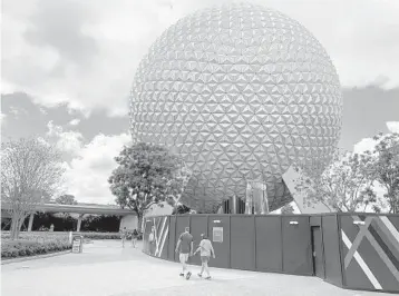  ?? DEWAYNE BEVIL/ORLANDO SENTINEL ?? Visitors arrive at Epcot, passing by constructi­on in front of Spaceship Earth.