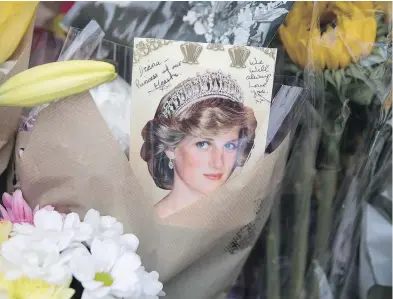  ?? DAN KITWOOD / GETTY IMAGES ?? Well-wishers gather outside the gates of Kensington Palace on Thursday in London, where tributes continue to be left on the 20th anniversar­y of the death of Princess Diana.