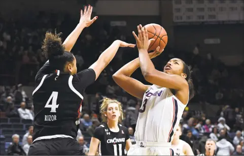  ?? Jessica Hill / Associated Press ?? UConn’s Megan Walker, right, shoots over Cincinnati’s Angel Rizor in the first half of Thursday’s win in Storrs.