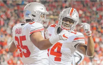  ?? | GETTY IMAGES ?? Marcus Baugh and K. J. Hill whoop it up after a TDby Ohio State, which jumped to No. 1 in our Big Ten power rankings.