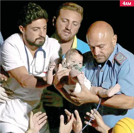  ??  ?? A doctor and a police officer carry seven-month-old Pasquale Toscano from the debris yesterday