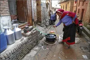  ?? PHOTOS BY PURNIMA SHRESTHA / NEW YORK TIMES ?? A woman fills containers from the water supplied sporadical­ly by the Nepalese government in Kathmandu recently. As the world warms, private tanker companies around the globe are making money from worsening water scarcity.