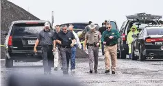  ?? DANNY ZARAGOZA/LAREDO MORNING TIMES VIA AP ?? Law enforcemen­t officers gather at the scene where the body of a woman was found near Interstate 35 north of Laredo, Texas, on Saturday. A U.S. Border Patrol agent suspected of killing four women was arrested early Saturday after a fifth woman who had been abducted managed to escape from him and notify authoritie­s, law enforcemen­t officials said, describing the agent as a ‘serial killer.’