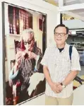  ??  ?? Photograph­er Arnel Villegas beside his portrait of National Artist Victorio Edades