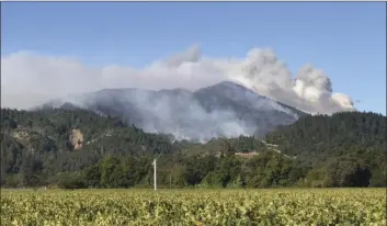  ??  ?? A nearby mountainto­p is seen smoldering earlier this month during a wildfire in the Napa region that a local strike team was deployed to provide mutual assistance for. PHOTO COURTESY OF THE HOLTVILLE FIRE DEPARTMENT