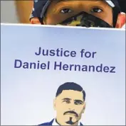  ?? Luis Sinco Los Angeles Times ?? MATTHEW HERNANDEZ, 8, holds a sign with a picture of his uncle Daniel Hernandez at a news conference Friday at the L.A. County Hall of Justice.