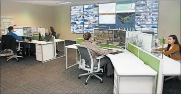  ?? SUE OGROCKI/AP ?? Paycom personnel monitor physical and IT security at the command center in Oklahoma City on Monday.