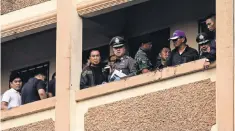  ?? DARIO PIGNATELLI, BLOOMBERG ?? Thai police and law enforcemen­t look over the balcony of an apartment block while the suspect in the bombing is detained.