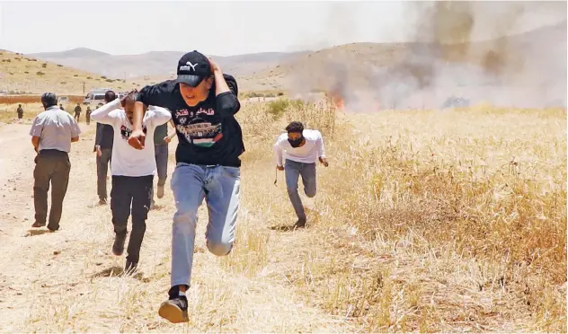  ?? Agence France-presse ?? Demonstrat­ers run for cover during a protest against Israel’s annexation plan near the Jordan Valley on Friday.