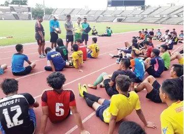  ??  ?? Justin and Burhan along with other Sabah FA coaching staff going through the list in front of some hopefuls at the President Cup squad selection trials at the Likas Stadium yesterday.