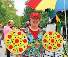  ??  ?? Caricaturi­st David C. Perry of Norristown shows off some of his props of “pizzas” to his “pet” toucan.